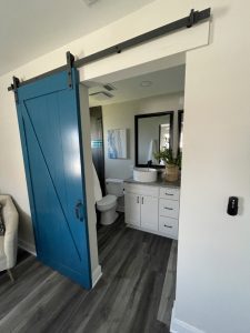 Primary suite entry with blue barn door and bathroom vanity