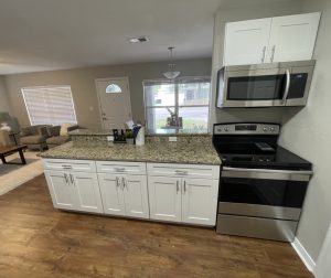 Remodeled kitchen island with granite countertop and stainless appliances