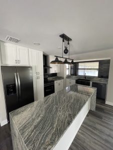 Remodeled kitchen with White Cabinets and a Dark Grey stone countertops with High End appliances and lighting